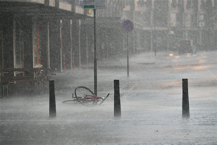 Forgotten bicycle attached on a road sign under heavy rain storm.Rotterdam,Netherlands.