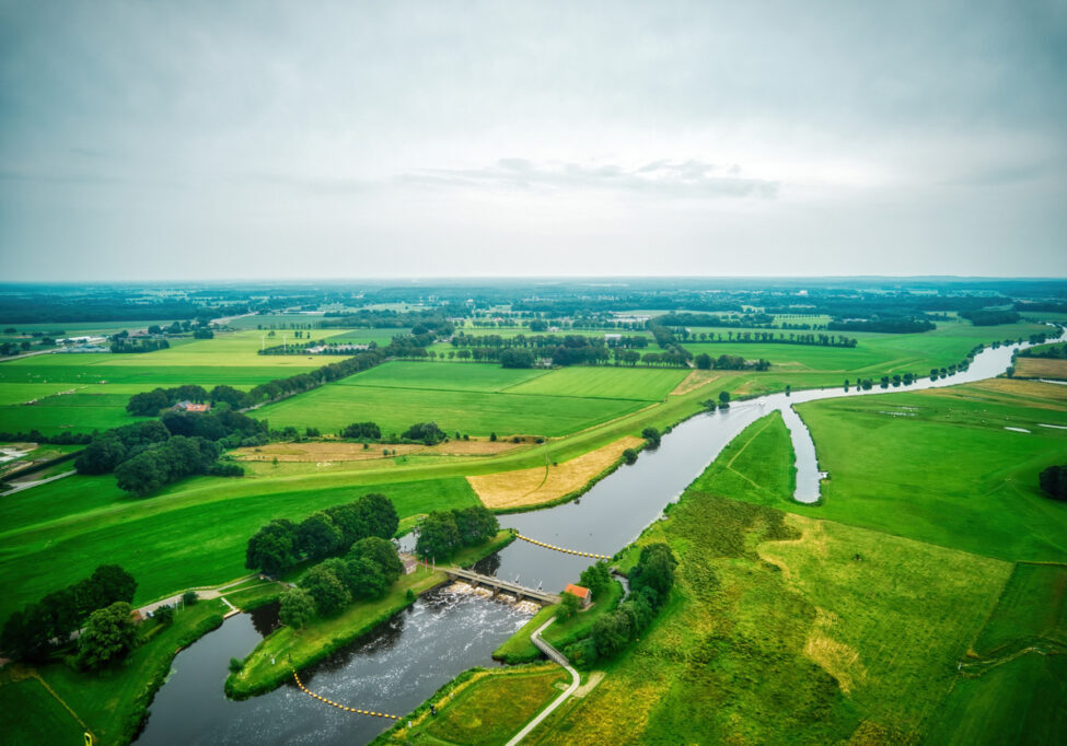 Airial view of a weir in the river Vecht. Dutch river in a colorful landscape. Water authority Drents Delta Overijssel.